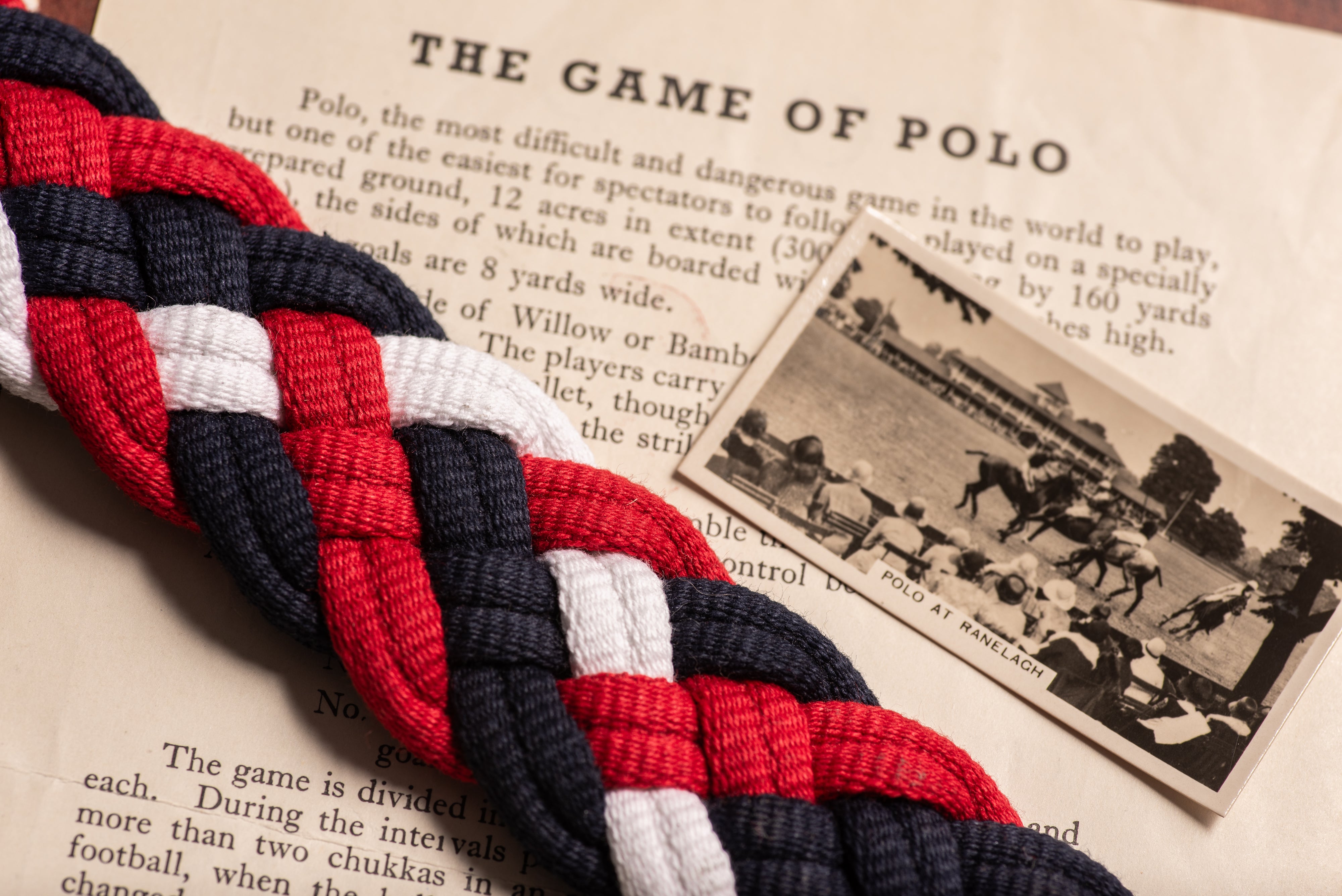 Close-up of hand-woven red, navy and white cotton braiding on handmade polo belt